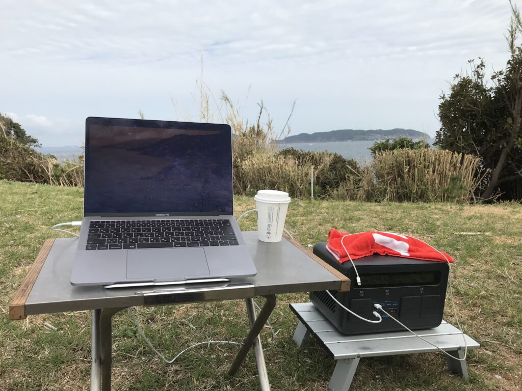 海の前でパソコン作業をしている