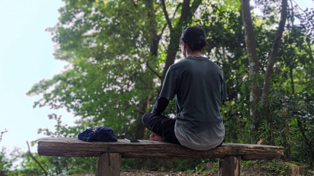 男が森で瞑想をしている